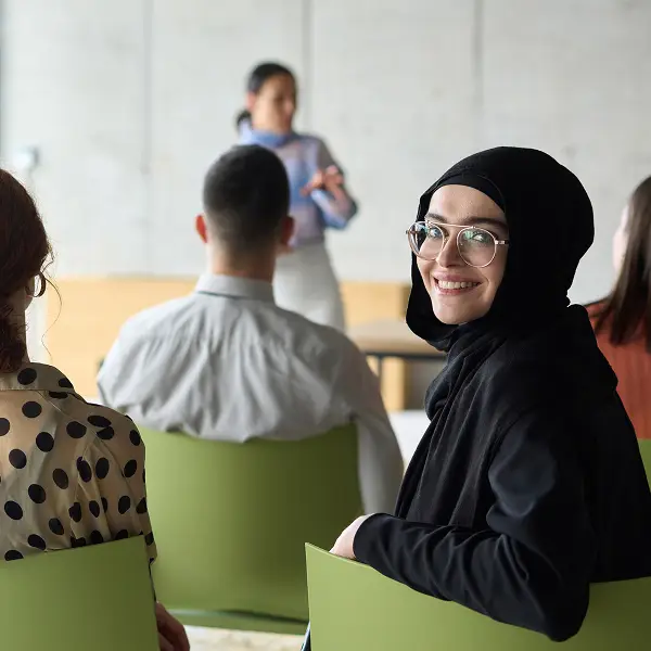 Pädagogische Fachkraft hört bei Weiterbildung zu.